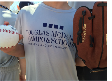 Boy holding ball and glove in Douglas McDaniel Campo & Schools uniform